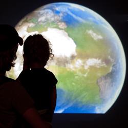 Father and daughter watching the NASA climate change exhibit